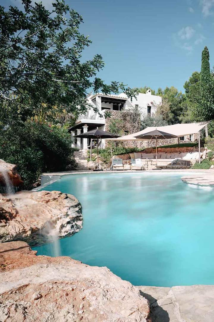 Pool mit geschwungener Form, Sonnenschirmen und mediterranem Garten mit Sitzbereich