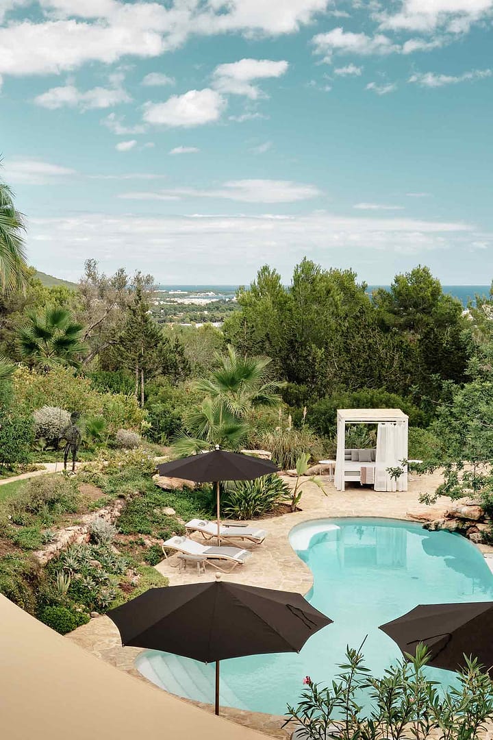 Pool mit geschwungener Form, Sonnenschirmen, Liegen und Lounge-Bereich im mediterranen Garten