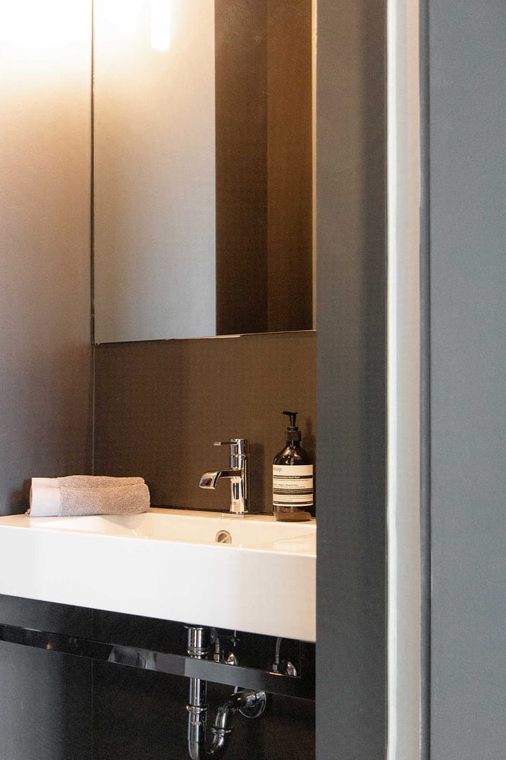 Design Apartment Berlin – Badezimmer mit Aesop-Seife, Handtuch und modernem Waschbecken