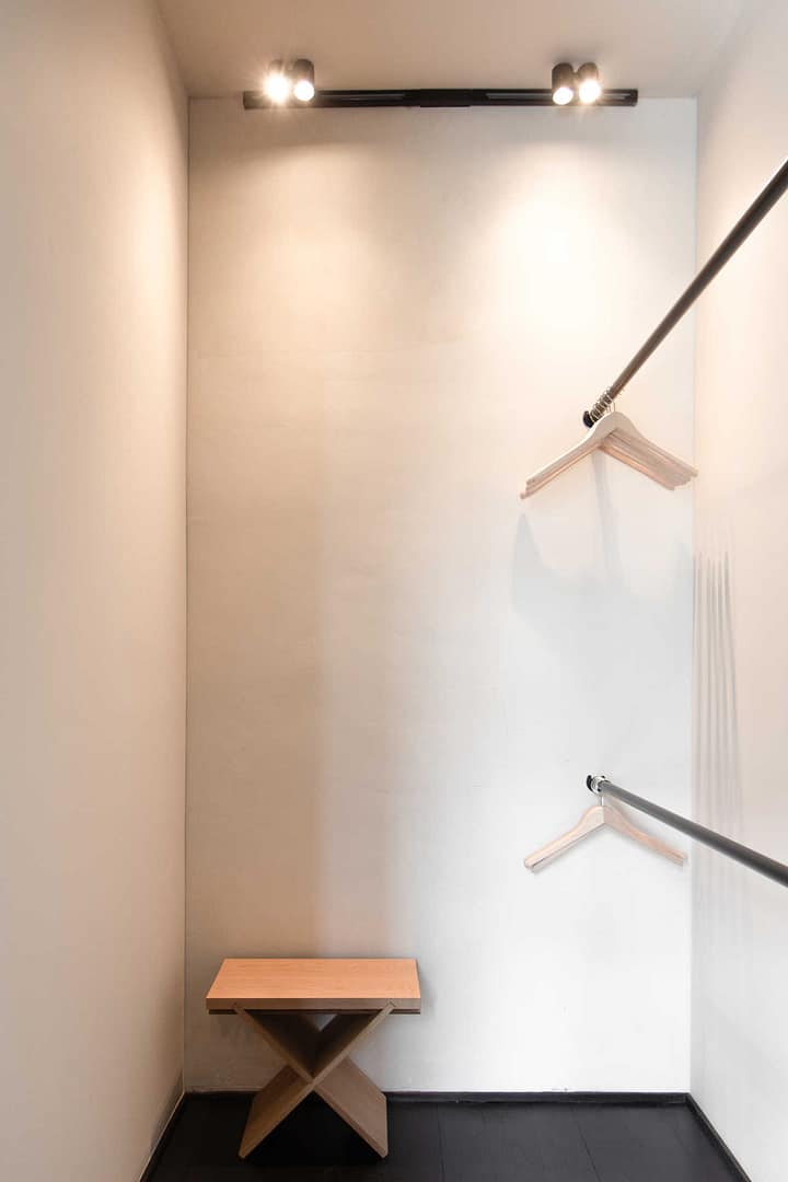 Design Apartment Berlin – begehbarer Kleiderschrank mit Holzbank und Kleiderstangen