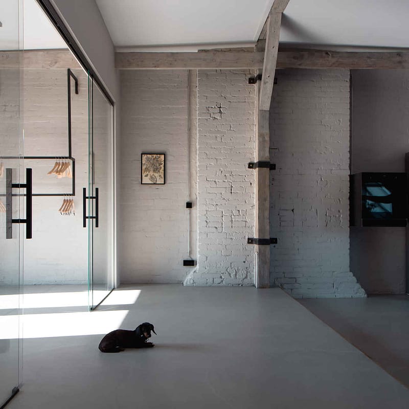 Design Studio Berlin – Loftküche mit freigelegten Balken, Industriekühlschrank und Glas-Schiebetür zum Ankleidebereich