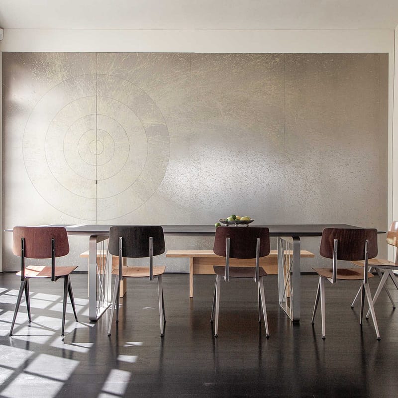 Design Apartment Berlin – minimalistischer Esstisch mit Stühlen vor silberner Wandkunst in lichtdurchflutetem Raum