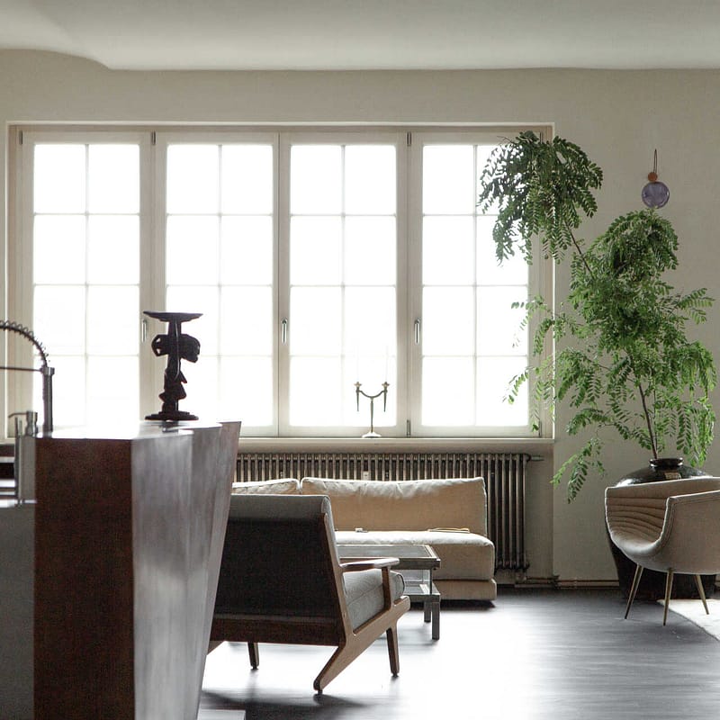 Design Apartment Berlin – offener Wohnbereich mit Kupferküche, Designmöbeln und großen Fenstern