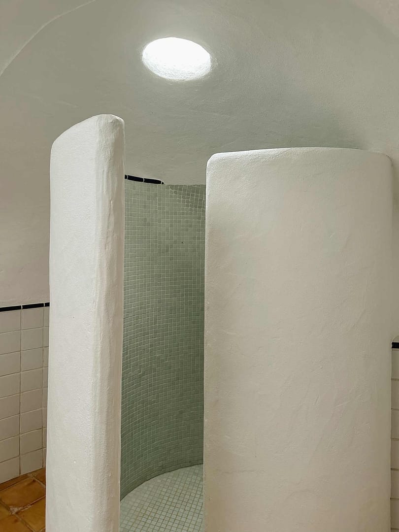 Kleine runde Dusche mit weißen Putzwänden und grünen Mosaikfliesen im Gästehaus einer Finca auf Ibiza